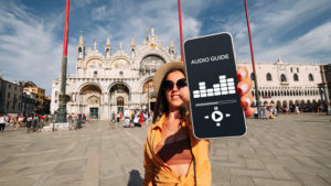 Tourist in Venice shows her phone with audio guides