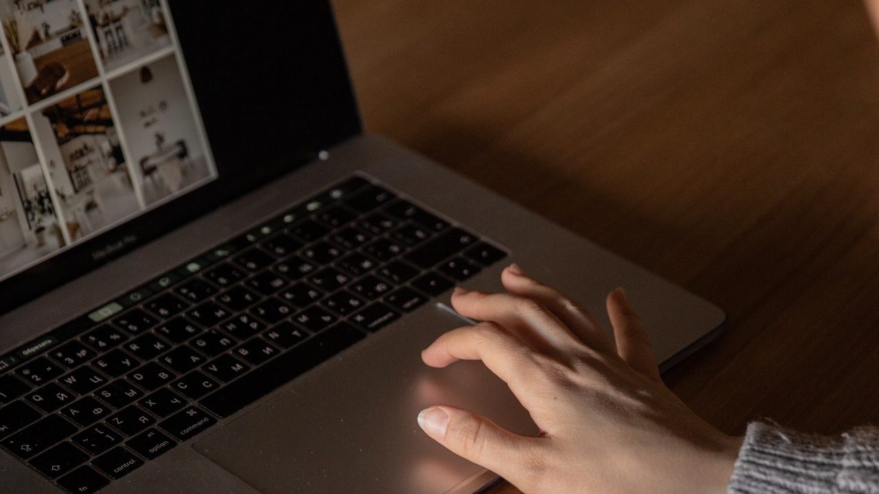 Detail of a hand using the PC while selecting photos of apartments