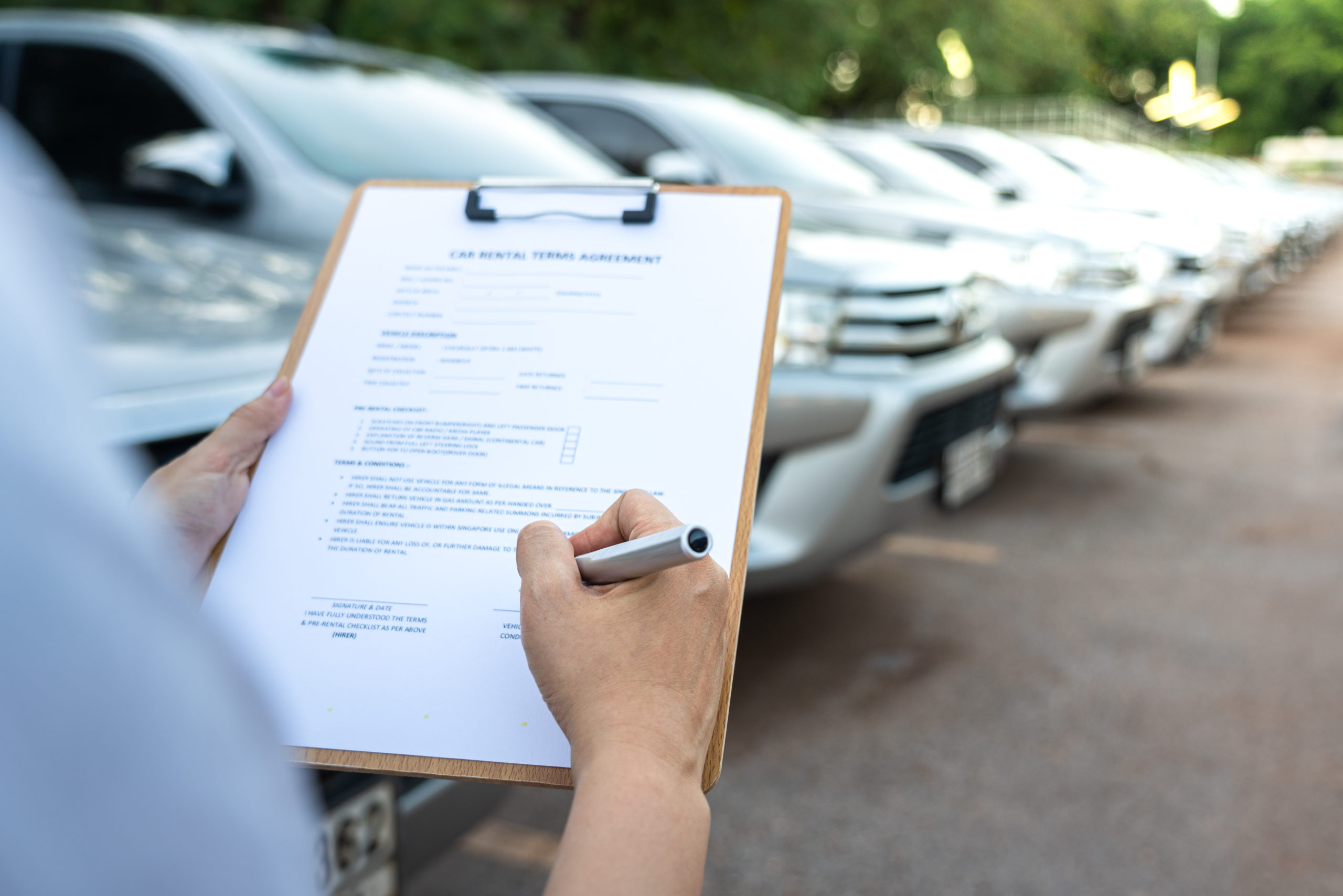 Car rental client signing rental agreement