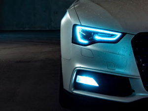 Detail of the blue headlight of an electric car